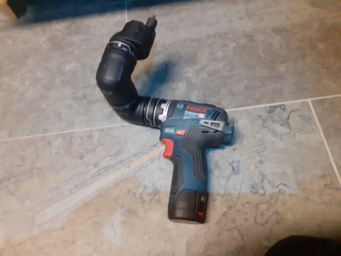 Batteridriven Bosch-skruvdragare med vinkelbart skaft på klinkergolv.
