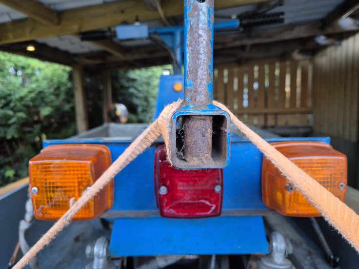 Elddriven flakmoppe Transportel 950 med rostig dragstång och remmar bakom sadeln, två orange och en röd lampa bak.