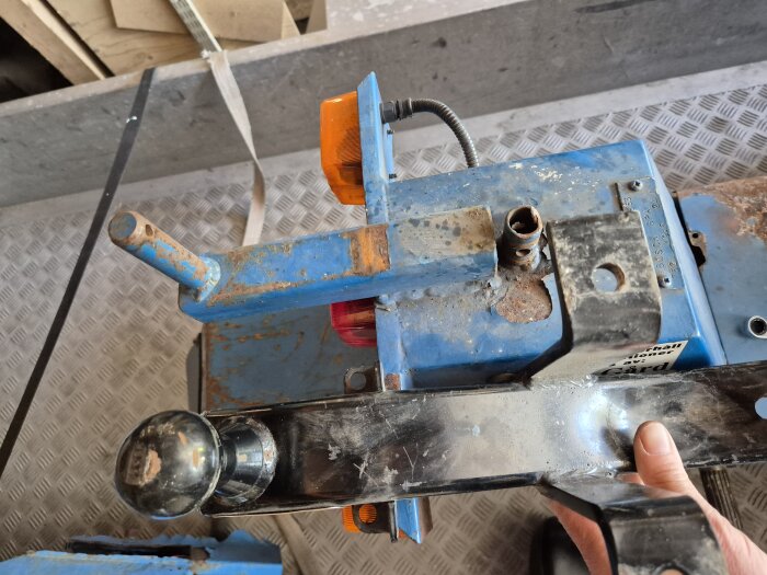 Eldriven flakmoppe Transportel 950 med draganordning och orange ljus, person håller 50 mm dragkula för montering på mopeden.