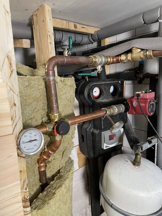 En installation av en fyrvägsshunt med kopparrör, isolering och en tryckmätare i ett värmesystem, planerad för en framtida motorshunt.