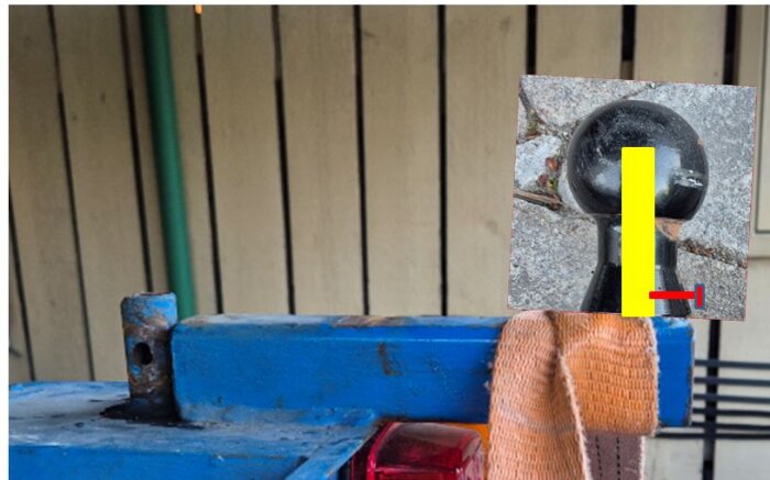 En borrad kula monterad på en avkortad pinne i en verkstadsmiljö med en pelarborrmaskin i bakgrunden.