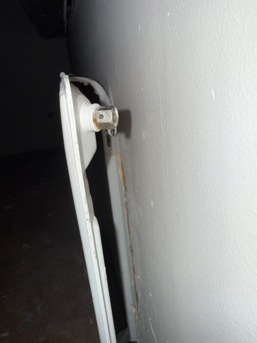 Läckande elementventil på ett vitt element mot en vit vägg.