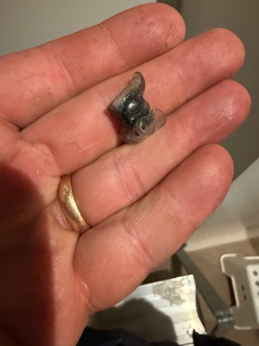 Bränd och smält elektrisk kopplingsklämma hålls i en hand.