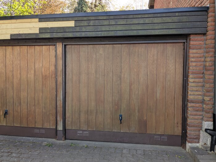 Två trädörrar av garage med färgskiftningar; vänster dörr endast tvättad, höger dörr slipad. Plankan mellan dörrarna är jämnare och mer välbehandlad.