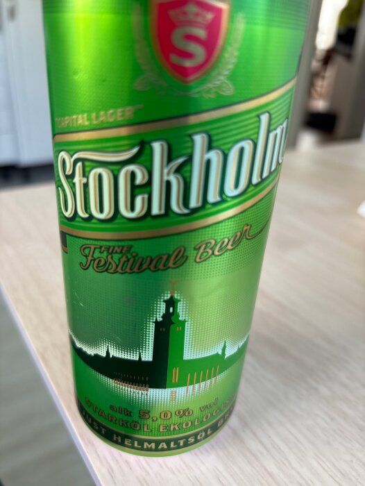 Grön burk med starköl, etikett märkt "Stockholm Fine Festival Beer" och illustration av ett torn och stadssiluett.