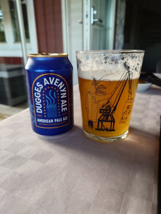 Burk och glas med Dugges Avenyn Ale på ett bord, med öppet fönster i bakgrunden.