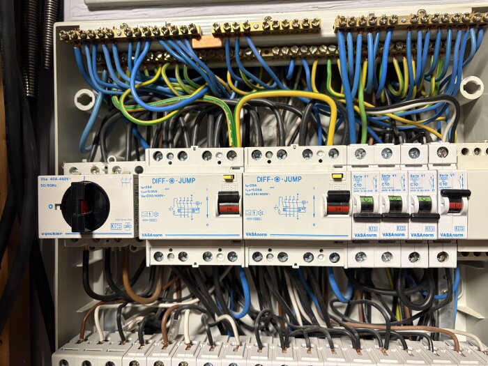 Elcentral med jordfelsbrytare och automatsäkringar, flera kablar anslutna.
