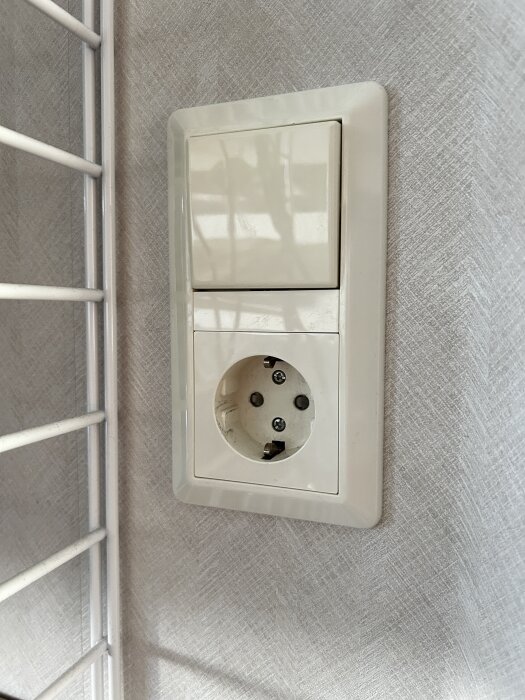 Kombinerad strömbrytare och vägguttag monterat på en vägg.