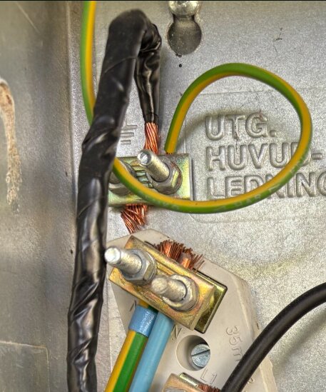 En bild av en elektrisk kopplingsplint där ledningar i olika färger är anslutna. Texten "UTG. HUVUDLEDNING" syns i bakgrunden.