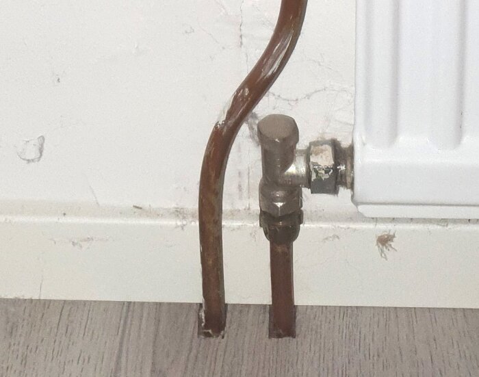 Ventil ansluten till ett element, där ett spår i ventilen kan ses för att justera flödet med en skruvmejsel.