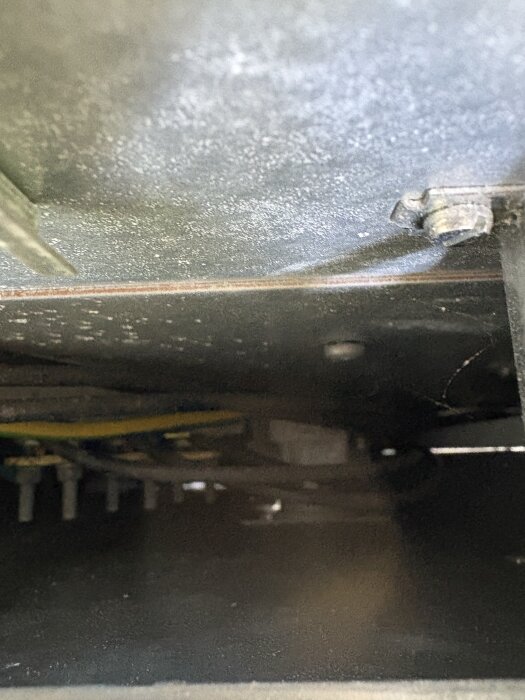 Inuti ett elskåp syns kablar och anslutningsplintar.