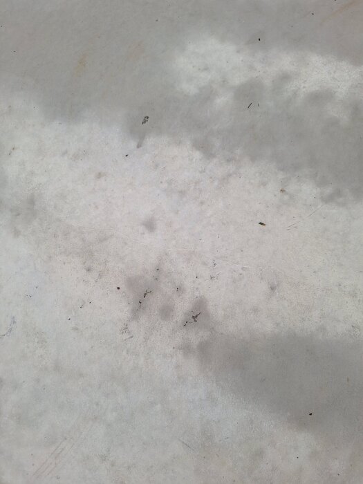 Betongyta med småhål och fläckighet, synlig ojämnhet efter tre månader av gjutning.