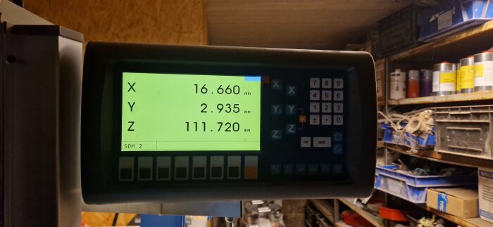 Digitalt display från maskin visar koordinaterna X: 16,660 mm, Y: 2,935 mm, Z: 111,720 mm.