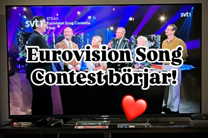 TV visar Eurovision Song Contest med texten "Eurovision Song Contest börjar!" och ett rött hjärta på skärmen.