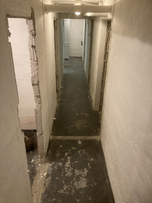 Gång med väggar reparerade med puts efter vattenskada och nyligen slipat golv.