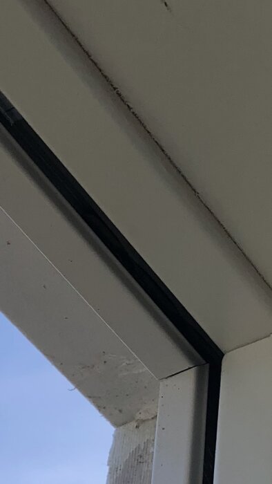 Aluminium hörn som har släppt från sin clips på träram och buktar ut.