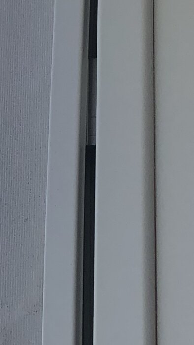 Aluminium har lossnat från clips på träramen och buktar ut.