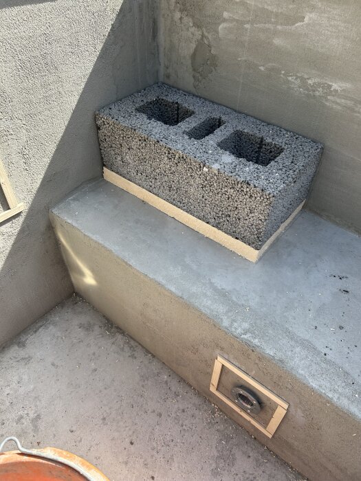 Trappstegsinstallation med lecablock ovanpå en gjuten betongplattform vid sidan av en pool.