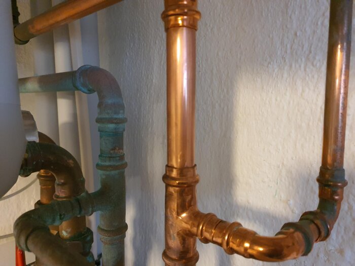 Ärgade kallvattenrör och opåverkade varmvattenrör i ett hem, rengjorda med husmorsknep för att ta bort ärg.