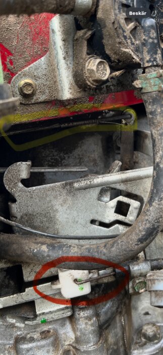 Närbild av Husqvarna Rider 13 Bioclip-mekanik med vajrar markerade i gula och röda cirklar, visar justeringsarmar och förgasardelar.