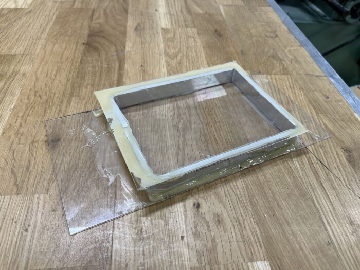 Fönsterprototyp med aluminiumram och tätade fogar ligger på arbetsbänk. Klar för att fyllas med gas för att undvika kondens.