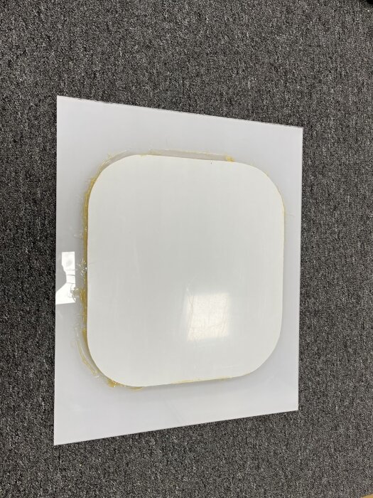Prototyp av fönster med extra stor glasruta för limning, placerad mot en mörkgrå texturerad yta.