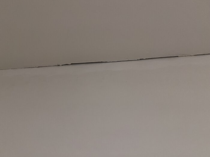 Stora springor mellan tak och vägg i källarrum där ombyggnad ej är färdigställd.