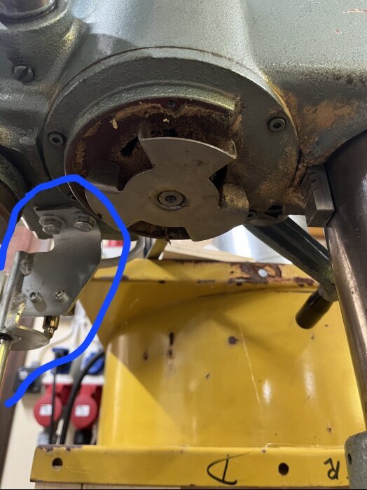 Fäste på maskinens undersida med blå markering, okänd funktion.