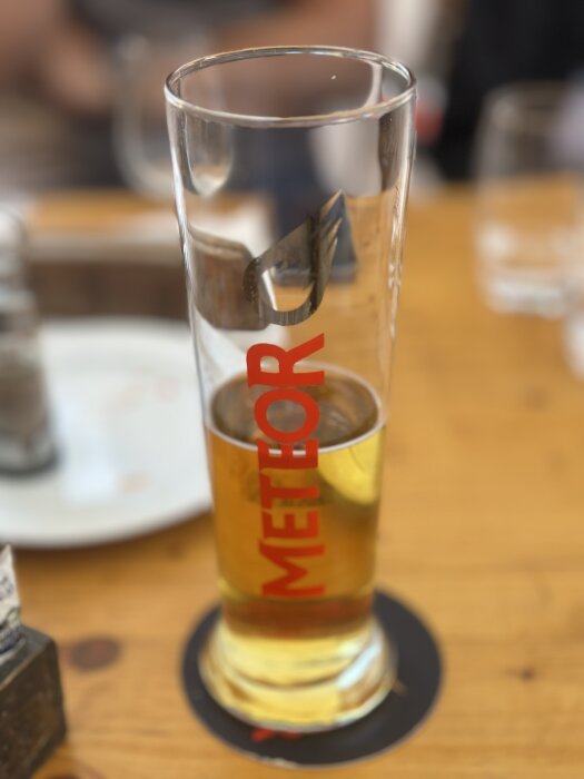 Ett högt glas med Meteor-öl på ett bord i Colmar, Frankrike.