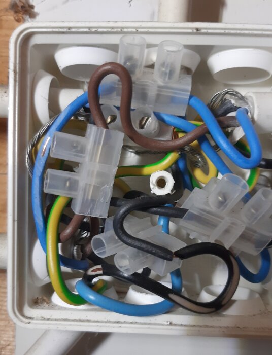 En kopplingsdosa med flera färgade kablar, några skadade så kopparn syns, upptäcktes i ett garage när utelampor kopplades bort.