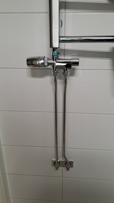 Handdukstork i ett-rörssystem utan bypass, med synliga rör och ventil på väggen, som påverkar hela husets värmecirkulation.