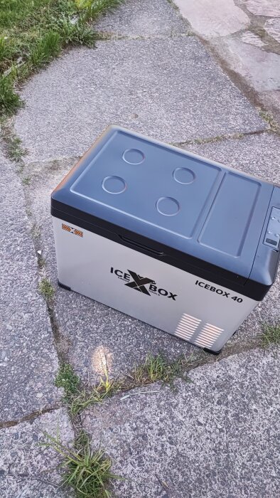 Kylboxen Ice Box 40 står på en stenlagd gång med gräs runtom.