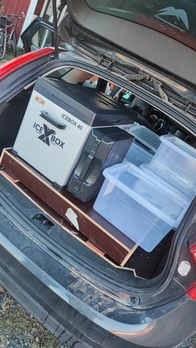 Bilen är packad med en kylbox och flera plastlådor i bagageutrymmet.