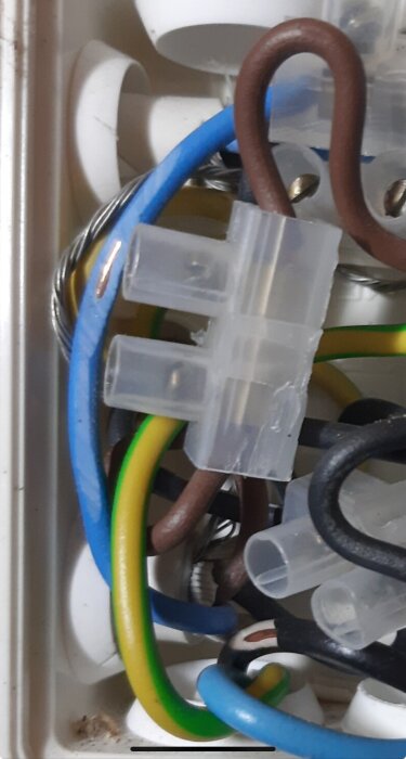 Närbild av flera färgglada elektriska kablar, inklusive blå, gula och bruna, med plastkopplingar i en kaotisk arrangemang.