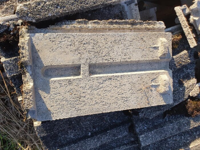 En hög med gamla betongtakpannor av en okänd modell från en raserad ladugård, diskussion om modell och intresse för återanvändning.