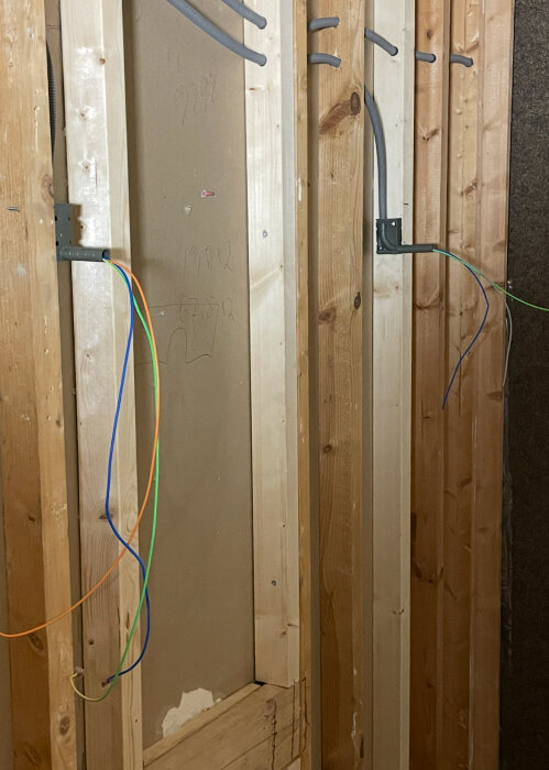 Vägg under renovering med elledningar dragna genom träreglar, illustrerar elinstallationskrav i badrumsprojekt.