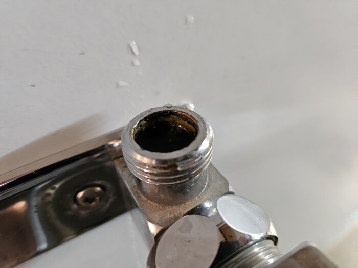 Gammalt FM Mattsson blandarfäste med konisk anslutning, visas tillsammans med en halvkoppling för PEX-rör.