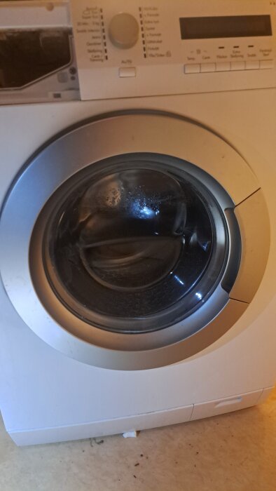 Framsida av en Husqvarna tvättmaskin, modell QW 167270, med luckan stängd och kontrollpanel synlig.