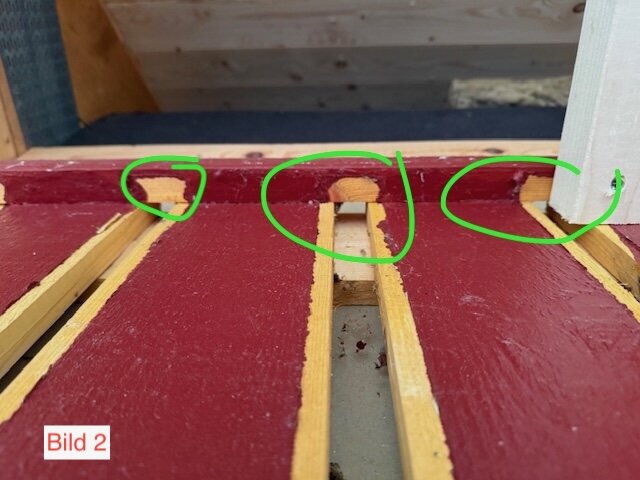 Röd fasad med hål markerade i grönt för ventilation mellan väggen och spikläkten på ett isolerat uterum.