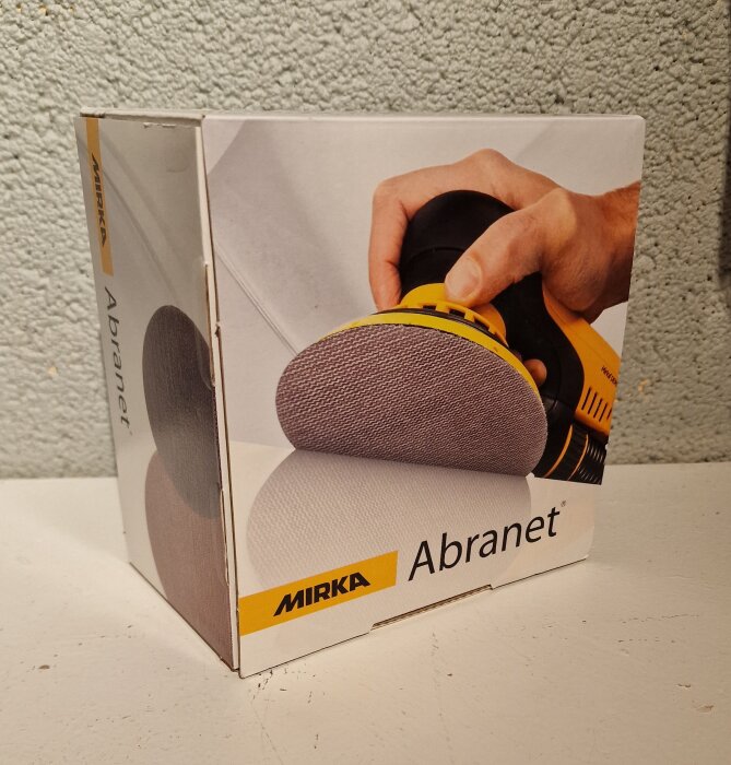 Förpackning med Mirka Abranet sliprondeller, 50-pack, med bild på en hand som håller en slipmaskin.