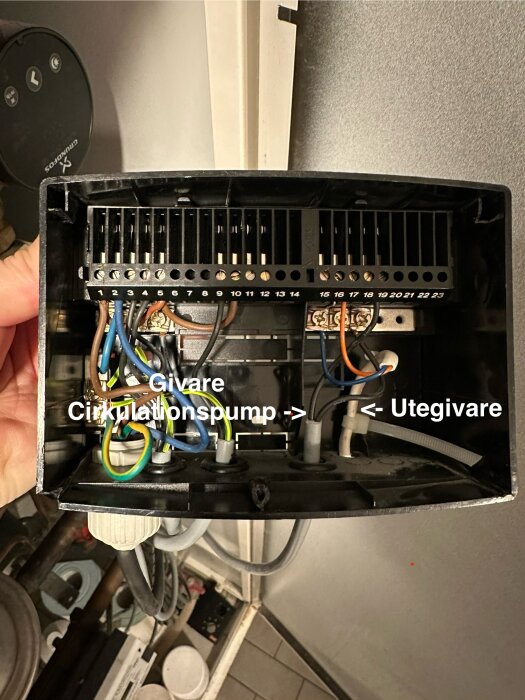 Öppen kopplingsbox med olika anslutna kablar. Text visar "Givare Circulationspump" och "Utegivare" med pilar som pekar mot kablar.