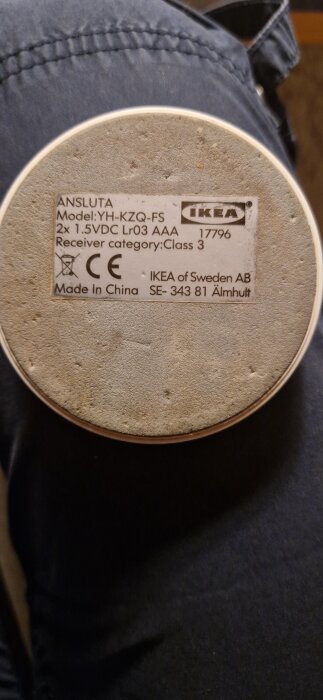 Närbild av Ikeas Ansluta fjärrkontrollens undersida med modellnummer YH-KZQ-FS och annan teknisk information på etiketten.