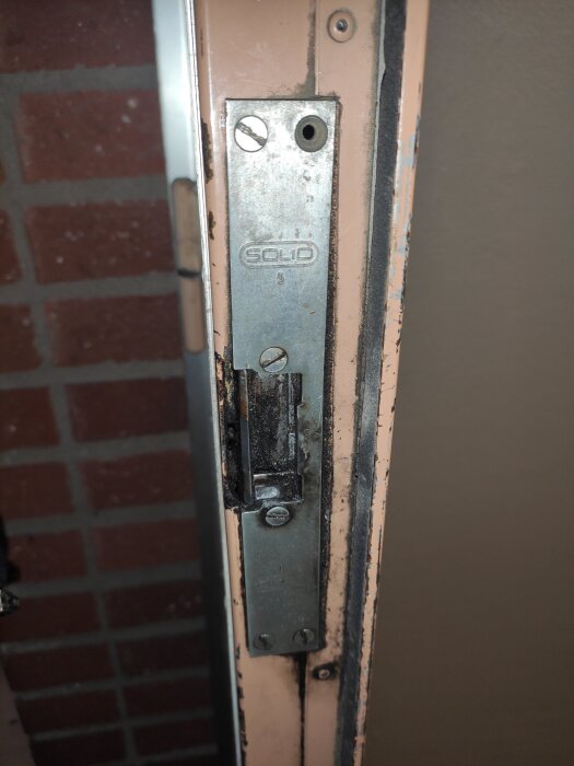 Elslutbleck på entrédörr i flerbostadshus, märkt med "Solid", visas i närbild.