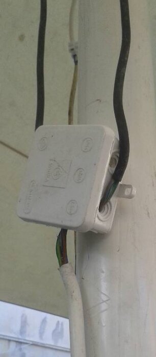 Elanslutningsbox fäst på parasollstolpe med flera kablar.