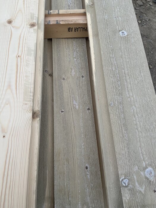 Behandlat virke av kärngran, placerat på en byggplats.