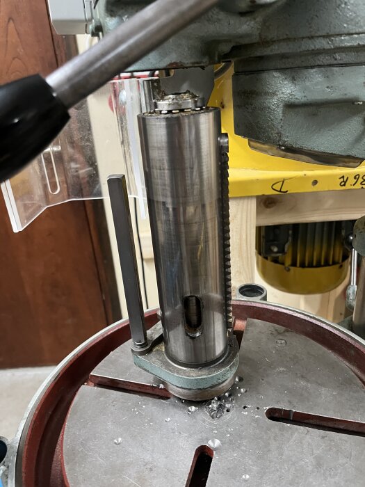 Verktygsmaskin med spindelhylsa och synligt lager, delvis demonterad för inspektion och underhåll av lagret i en verkstadsmiljö.