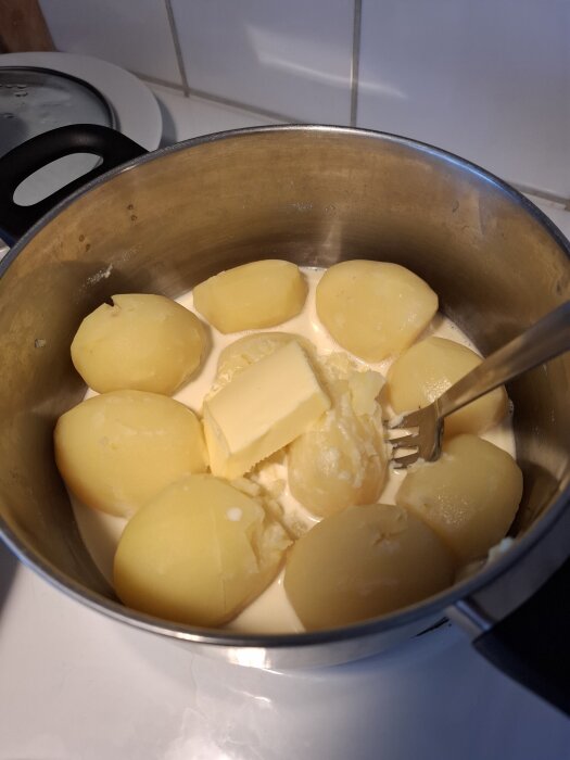 Kasrel med potatis, smör och grÀdde som förbereds för potatismos.