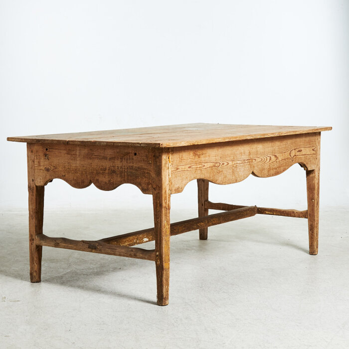 Rektangulärt träbord med lantlig stil och rustik finish, uppvisar naturlig trästruktur och varma färgtoner.