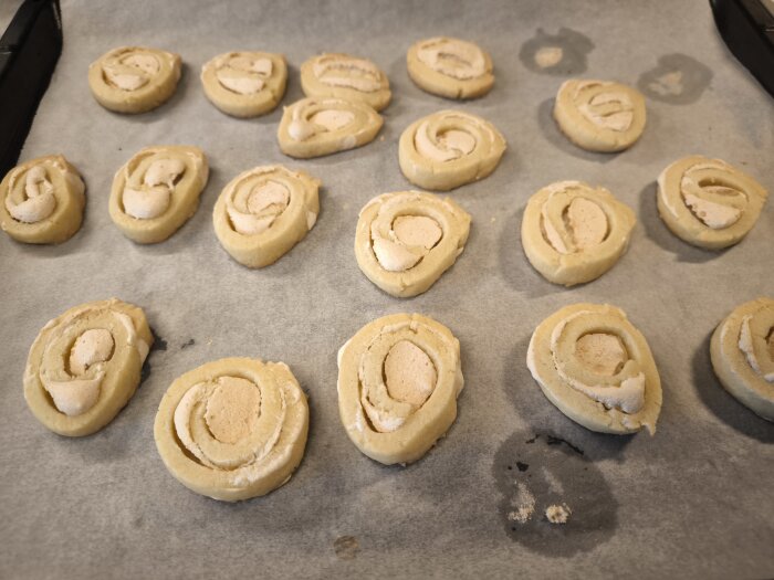 Bakade Jitterbuggare placerade på ett bakplåtspapper, redo för gräddning.