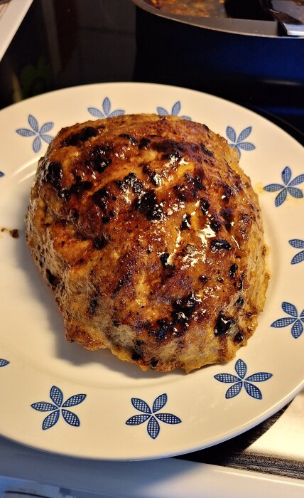 Köttfärslimpa på en vit tallrik med blå blommönster.